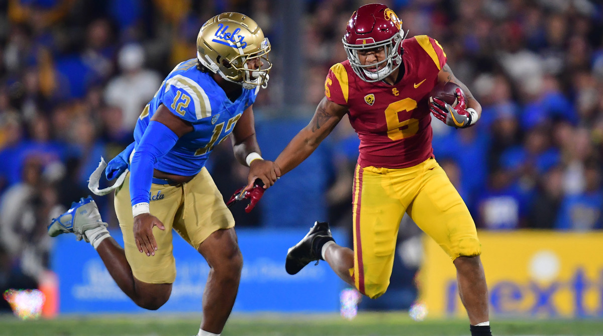 Southern California Trojans running back Austin Jones runs the ball against UCLA Bruins defensive lineman Grayson Murphy.